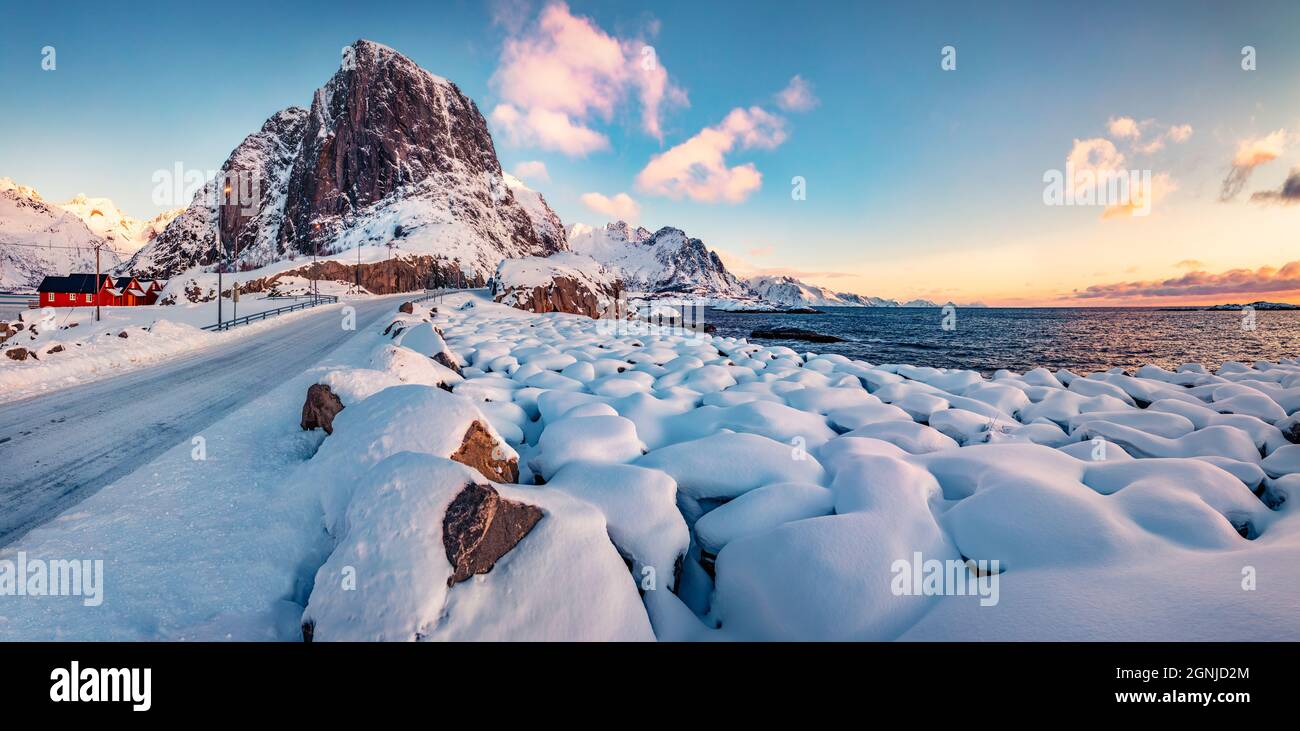 Lever de soleil d'hiver coloré sur le village de Hamnoy, îles Lofoten. Pierres couvertes de neige fraîche sur les rives de la mer de Norvège. Parfaite scène matinale de Norvège, Banque D'Images
