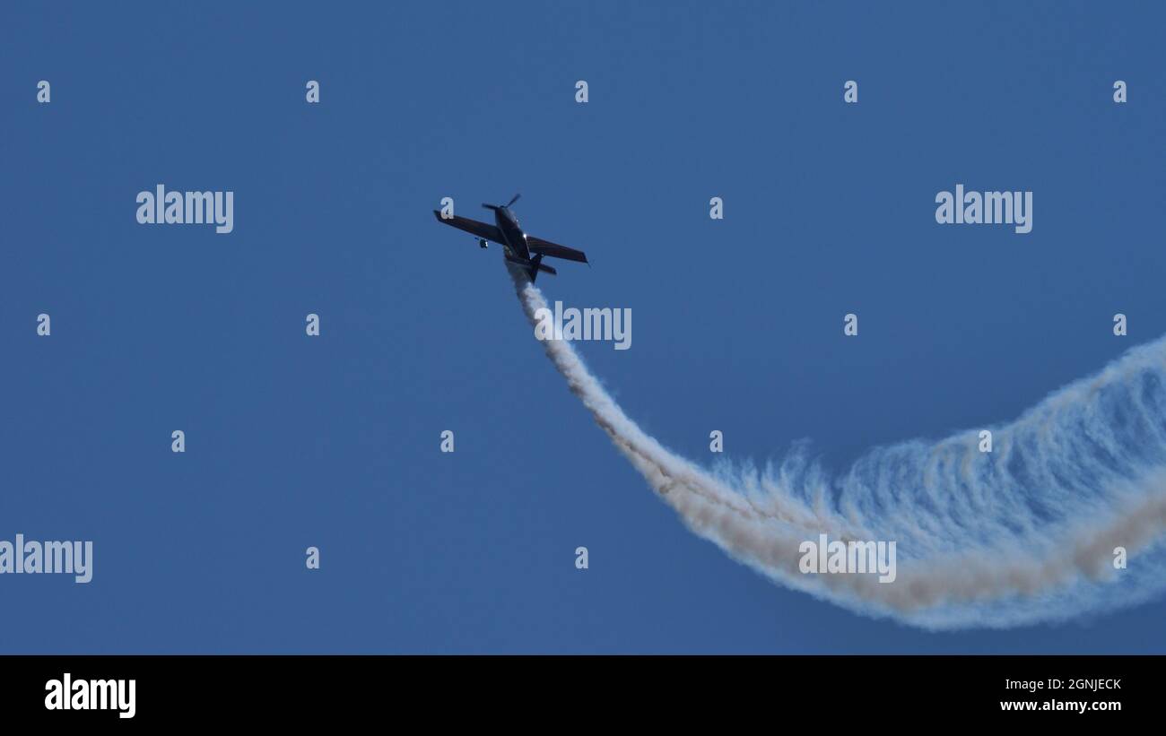 Maribor Airshow Slovénie AOÛT, 15, 2021 l'avion aérobatique s'élève verticalement dans le ciel bleu, dessinant une parabole mise en évidence par la fumée blanche. MX Aircraft MXS par Veres Zoltan Banque D'Images