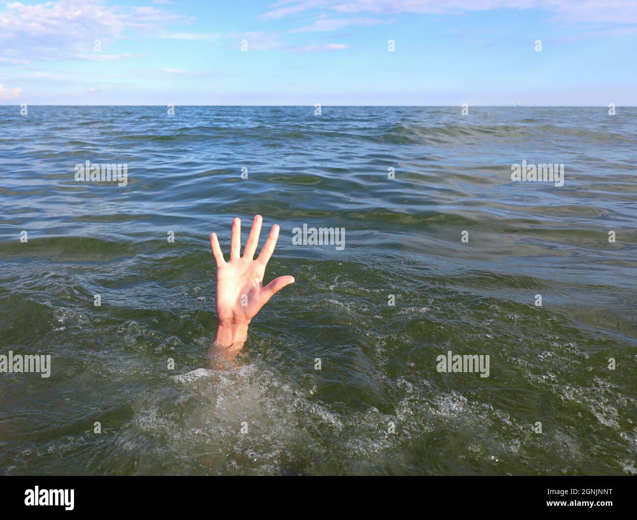 main du jeune homme en détresse qui se noie au milieu de la mer Banque D'Images