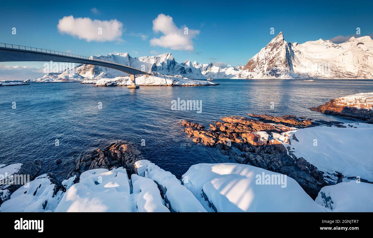 Scène hivernale enneigée du village de Hamnoy avec pont de Hamnoy, îles Lofoten. La neige fraîche couvrait des pierres et des sommets de montagne sur les rives de la mer norvégienne. Banque D'Images
