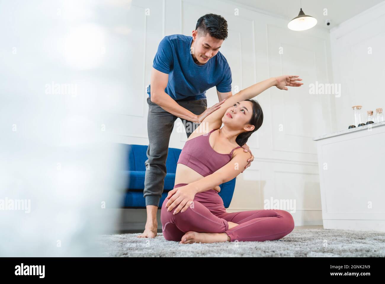 Exercices à la maison concept, asiatique Coaching Yoga hommes aider et soutenir sa petite amie quand l'exercice à la maison Banque D'Images