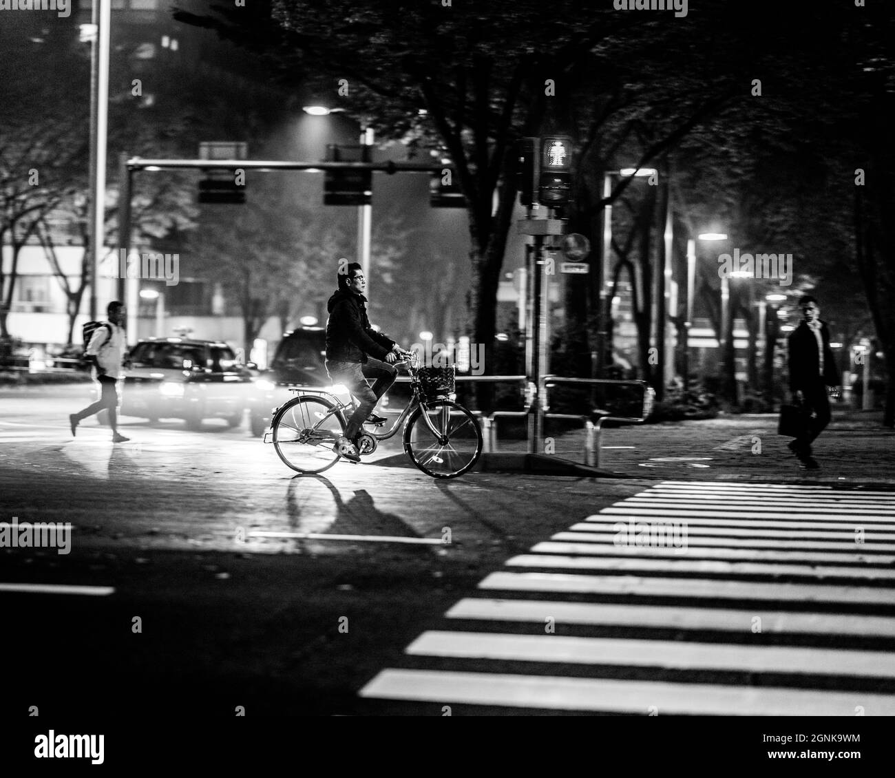 Vélo sous la pluie la nuit au Japon Tokyo Banque D'Images