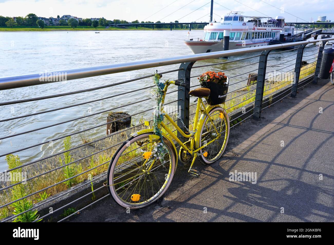 Vélo jaune avec publicité au restaurant 'Kasematten' sur la promenade du Rhin à Düsseldorf, en Allemagne. Banque D'Images