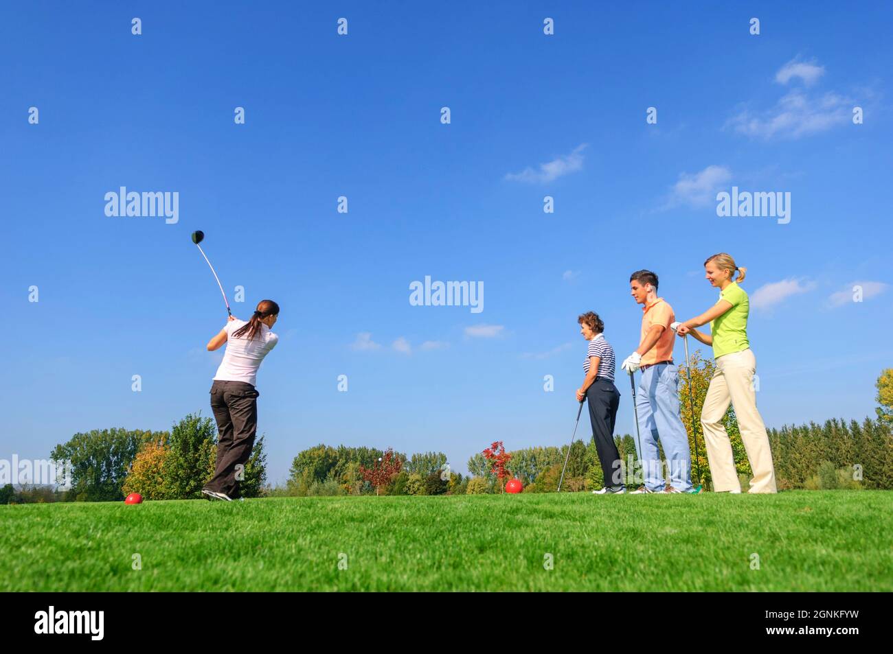 Les golfeurs observant le joueur tout en frappant une balle du tee Banque D'Images