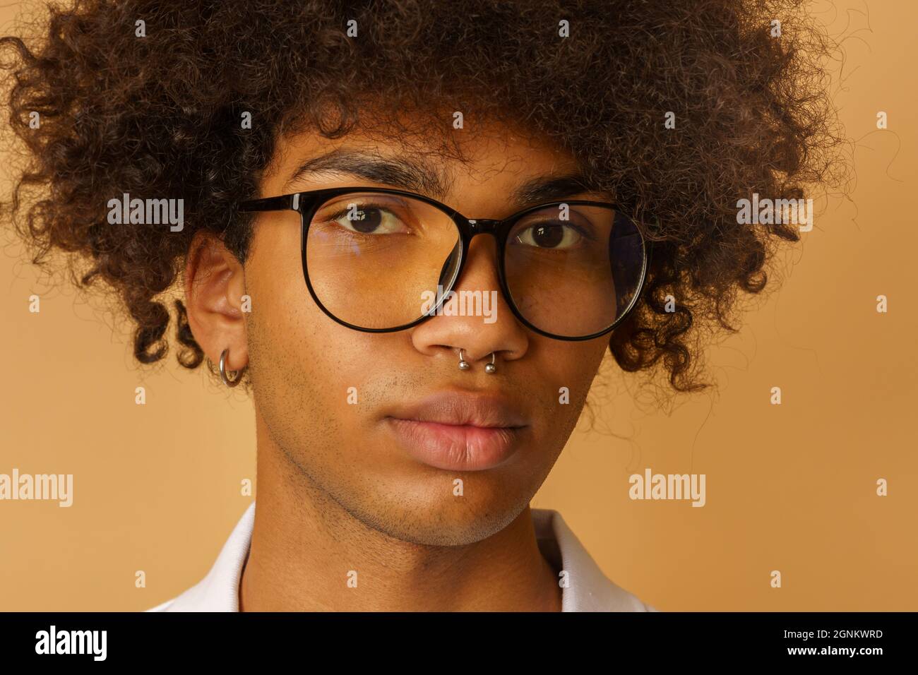 Homme afro sérieux avec des lunettes et le piercing Banque D'Images