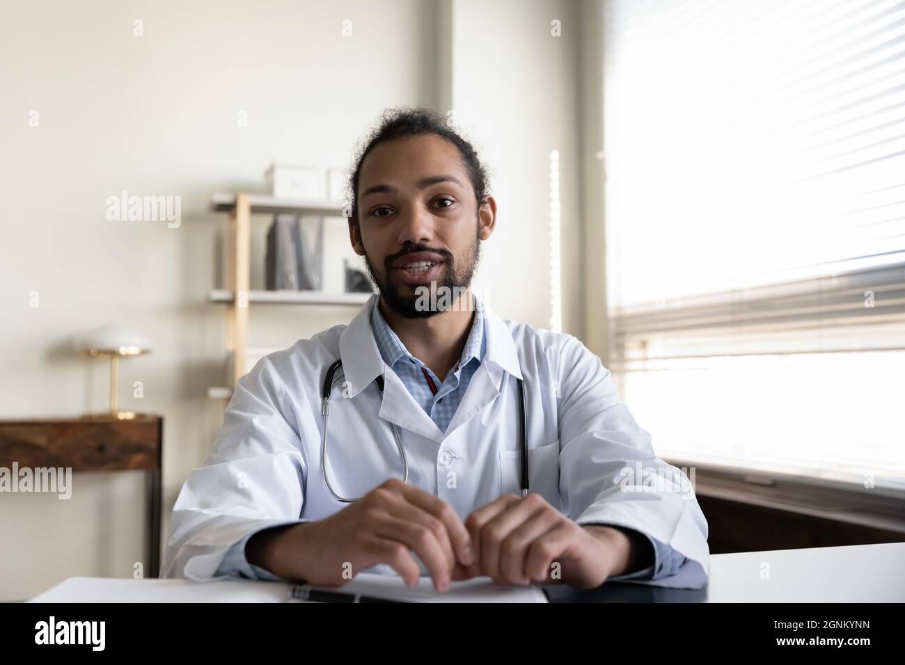 Empathétique jeune mixte race médecin donnant de l'aide en ligne Banque D'Images