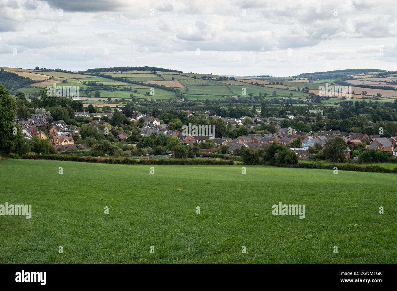 Village gallois niché dans la campagne vallonnée avec des champs verdoyants et des collines Banque D'Images