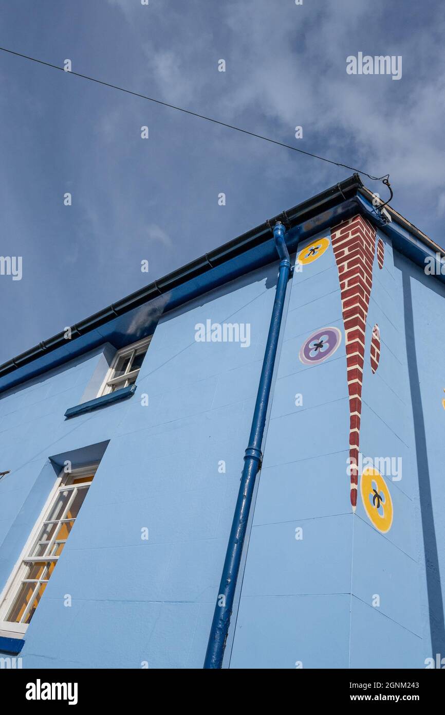 Maison colorée peinte en bleu avec des signes circulaires décoratifs sur le mur extérieur Banque D'Images