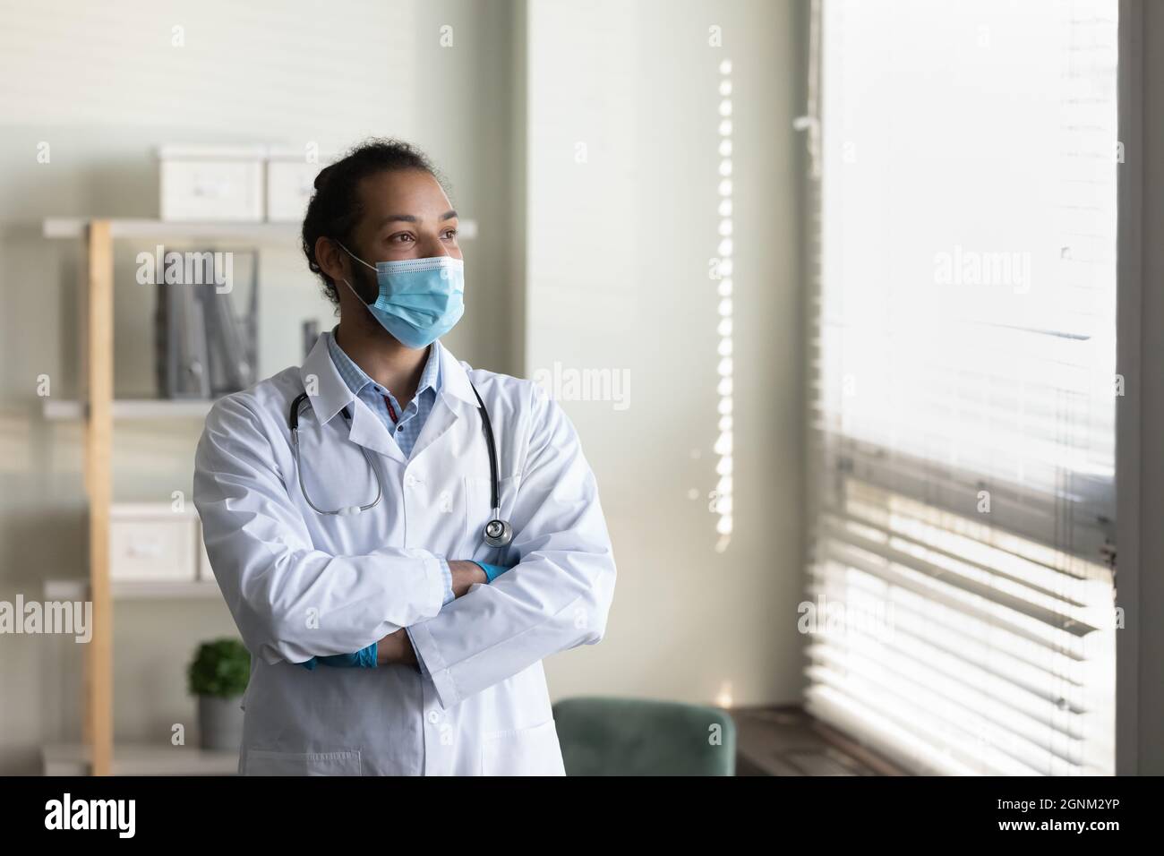 Médecin masculin sérieux dans le masque facial, manteau blanc avec stéthoscope Banque D'Images Médecin masculin sérieux dans le masque facial, manteau blanc avec stéthoscope Banque D'Images