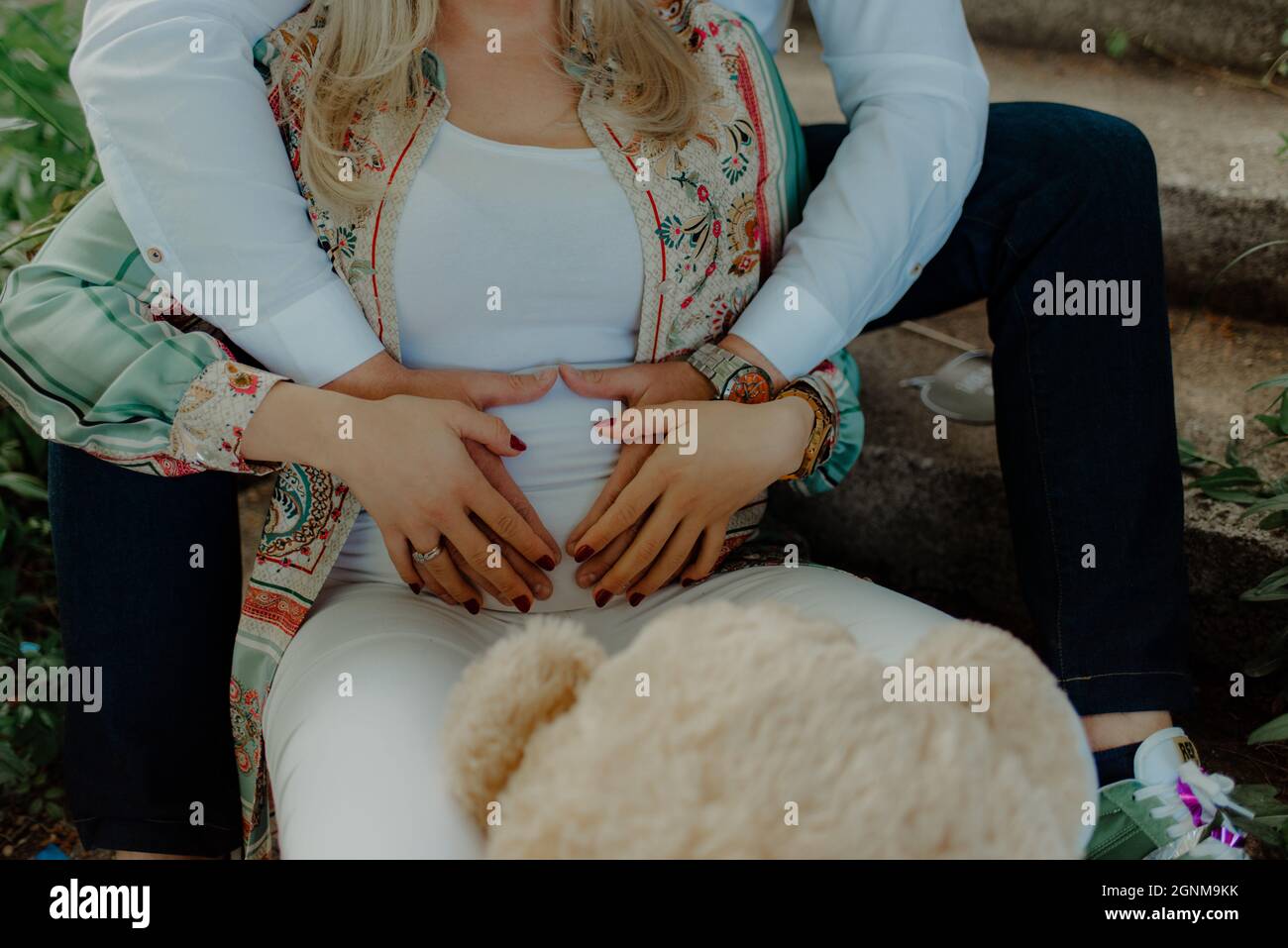 Le mari embrassant sa femme enceinte Banque D'Images