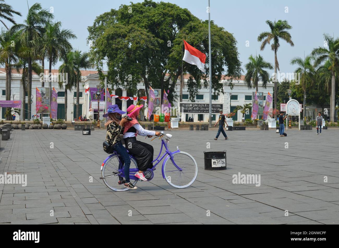 Deux jeunes femmes font un vélo à Kota Tua à Jakarta Banque D'Images