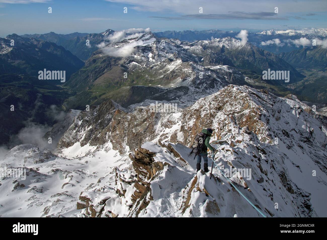 Alpiniste sur un sentier alpin difficile sur une crête rocheuse, Quintino Sella, Alpes Pennines, Vallée d'Aoste, Italie Banque D'Images