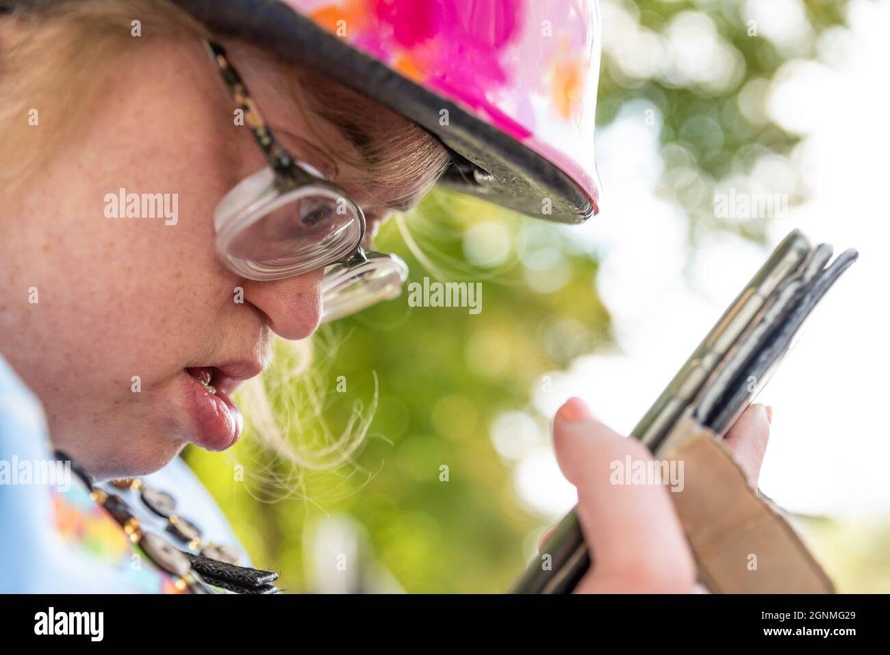 Femme blanche avec le syndrome de Down appelant sa famille avec un smartphone Banque D'Images