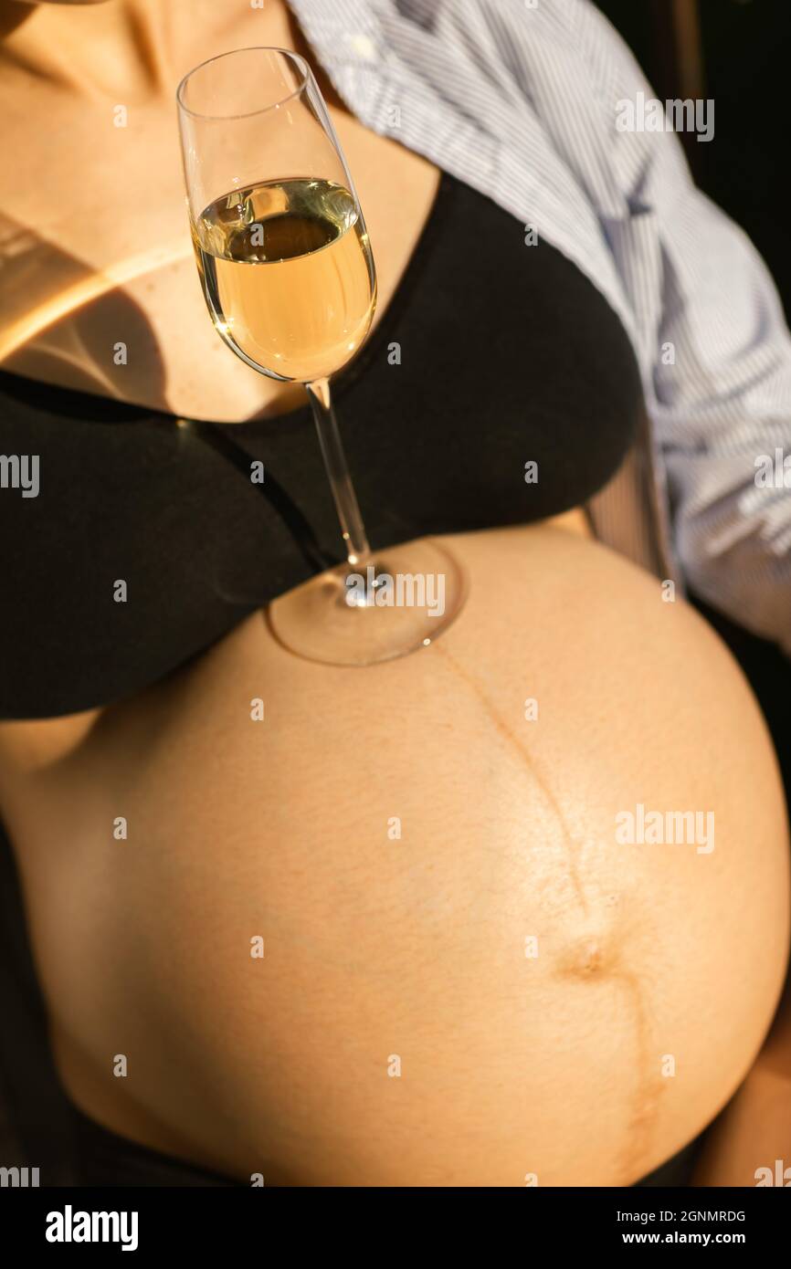 Femme enceinte avec un verre de vin. Alcool pendant la grossesse concept. Banque D'Images