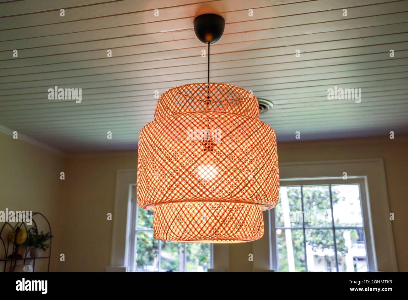 Une petite salle à manger avec un luminaire en rotin Banque D'Images