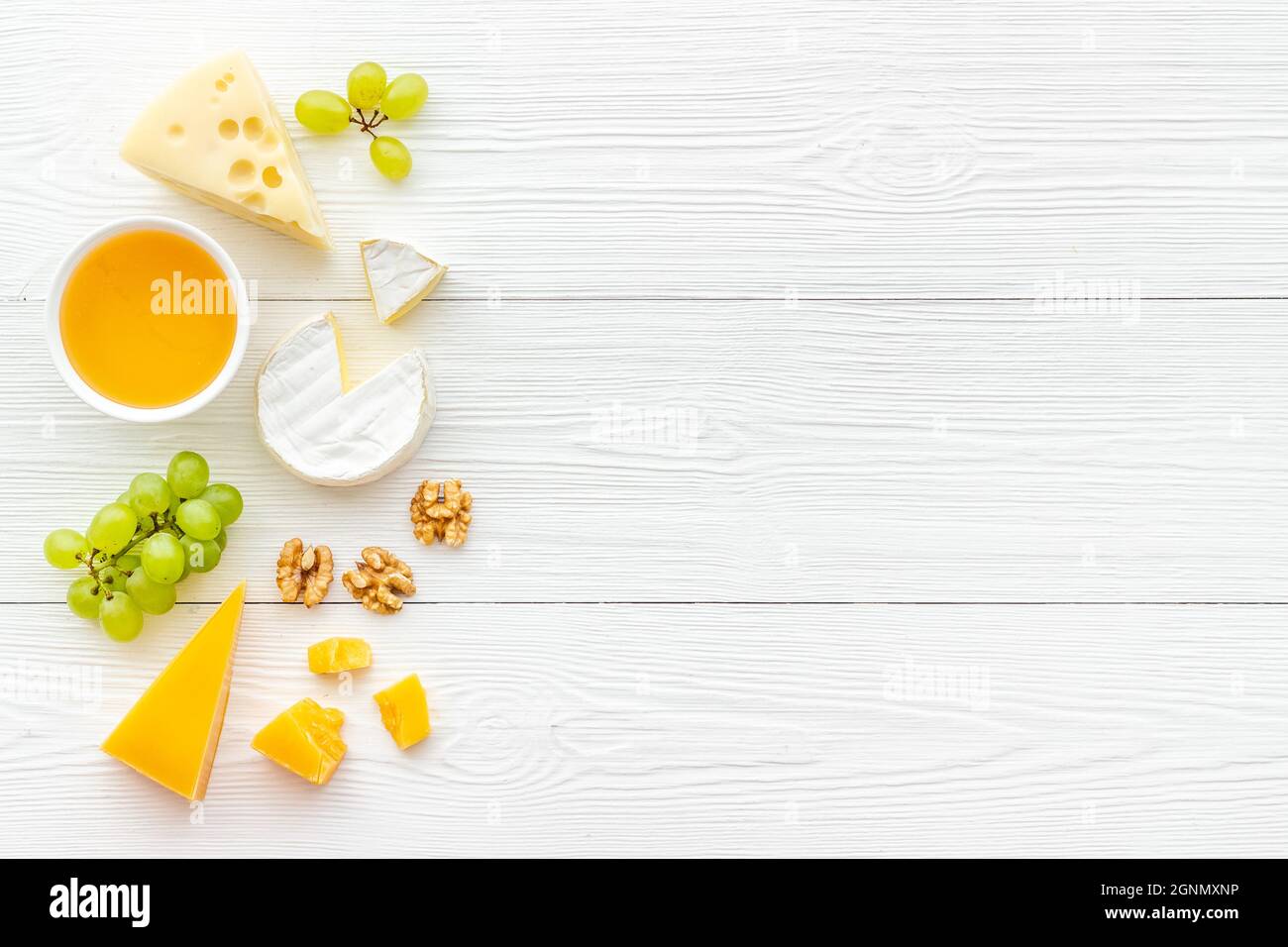 Divers types de fromage avec miel et raisins. Vue de dessus de la pose à plat Banque D'Images