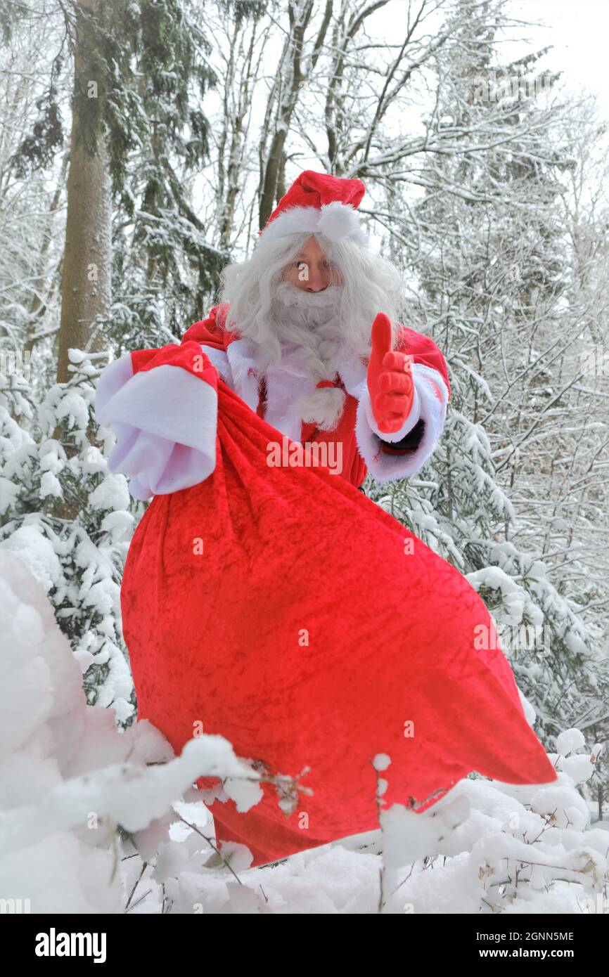 Le Père Noël et un sac de cadeaux dans la forêt enneigée d'hiver.Joyeux Noël. Noël et nouvel an Banque D'Images