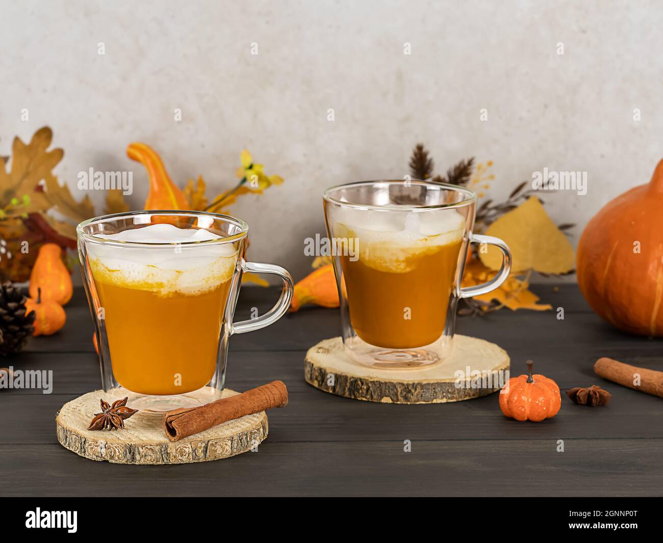 Latte aux épices de citrouilles en mugs de verre à la cannelle, à la muscade et à la crème fouettée. Banque D'Images