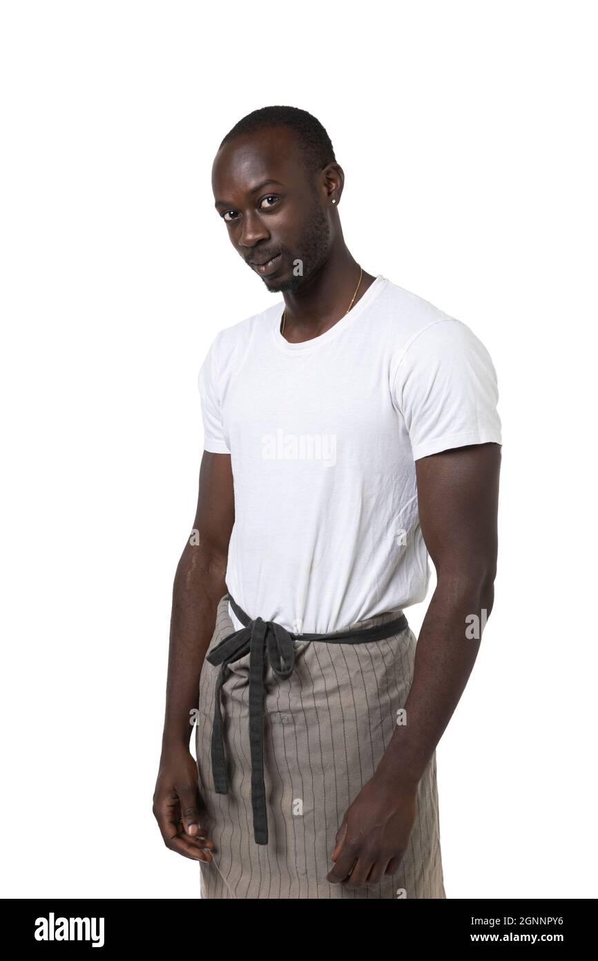 Un garçon africain avec un tablier pose trois quarts sur fond blanc en studio photo. Portrait en demi-longueur. Espace-copie Banque D'Images