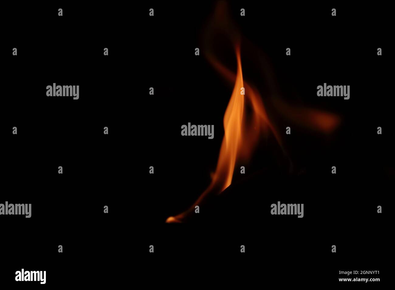 Gros plan d'Une flamme de feu flamboyante sur un fond noir Banque D'Images