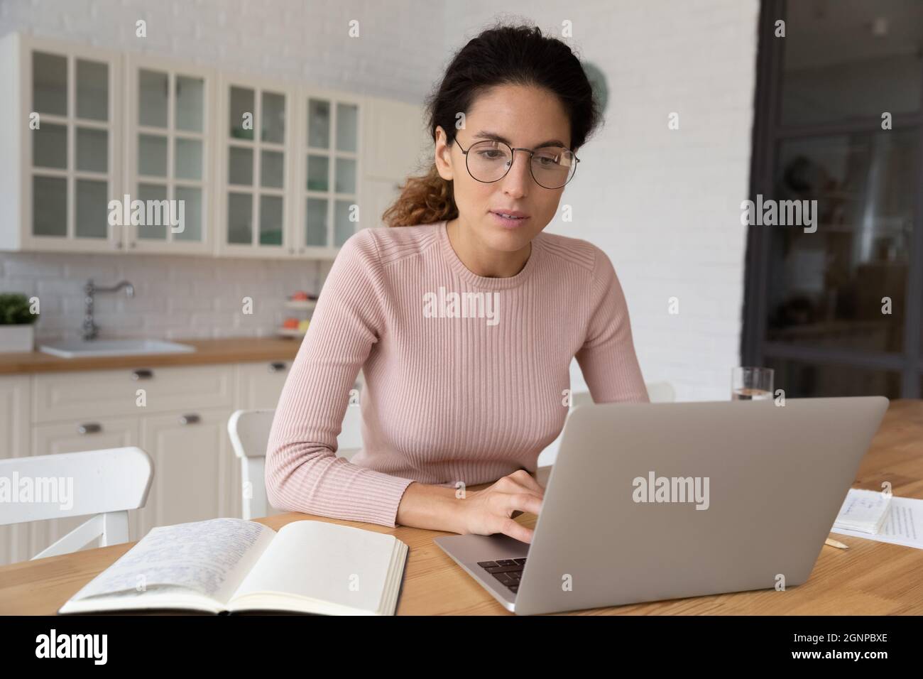 Une jeune femme pensive travaille sur un ordinateur portable Banque D'Images