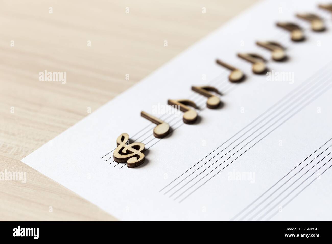 Notes musicales en bois sur une feuille de musique posée sur la table. Diagonale avec une faible profondeur de champ Banque D'Images