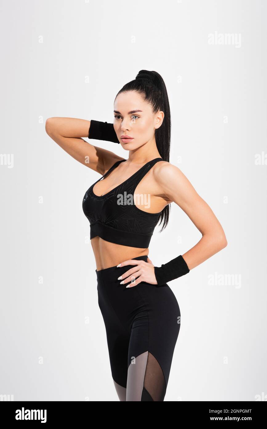 sportswoman confiant debout avec la main sur la hanche isolée sur le gris Banque D'Images