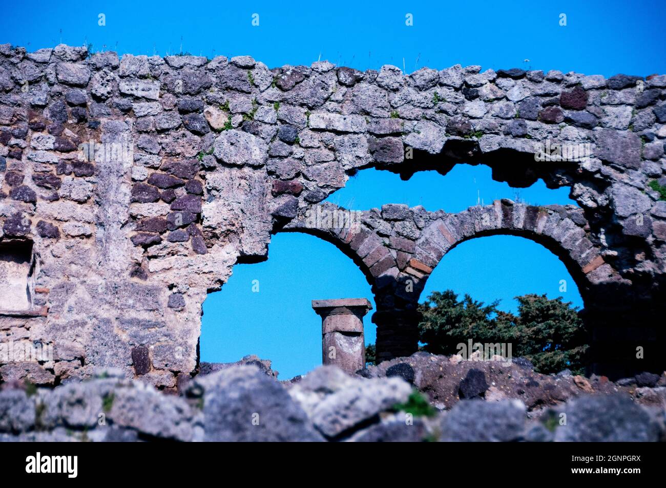 Mur de pierre voûté et colonne d'ordre dorique au Parc archéologique de Pompéi en Italie. Banque D'Images