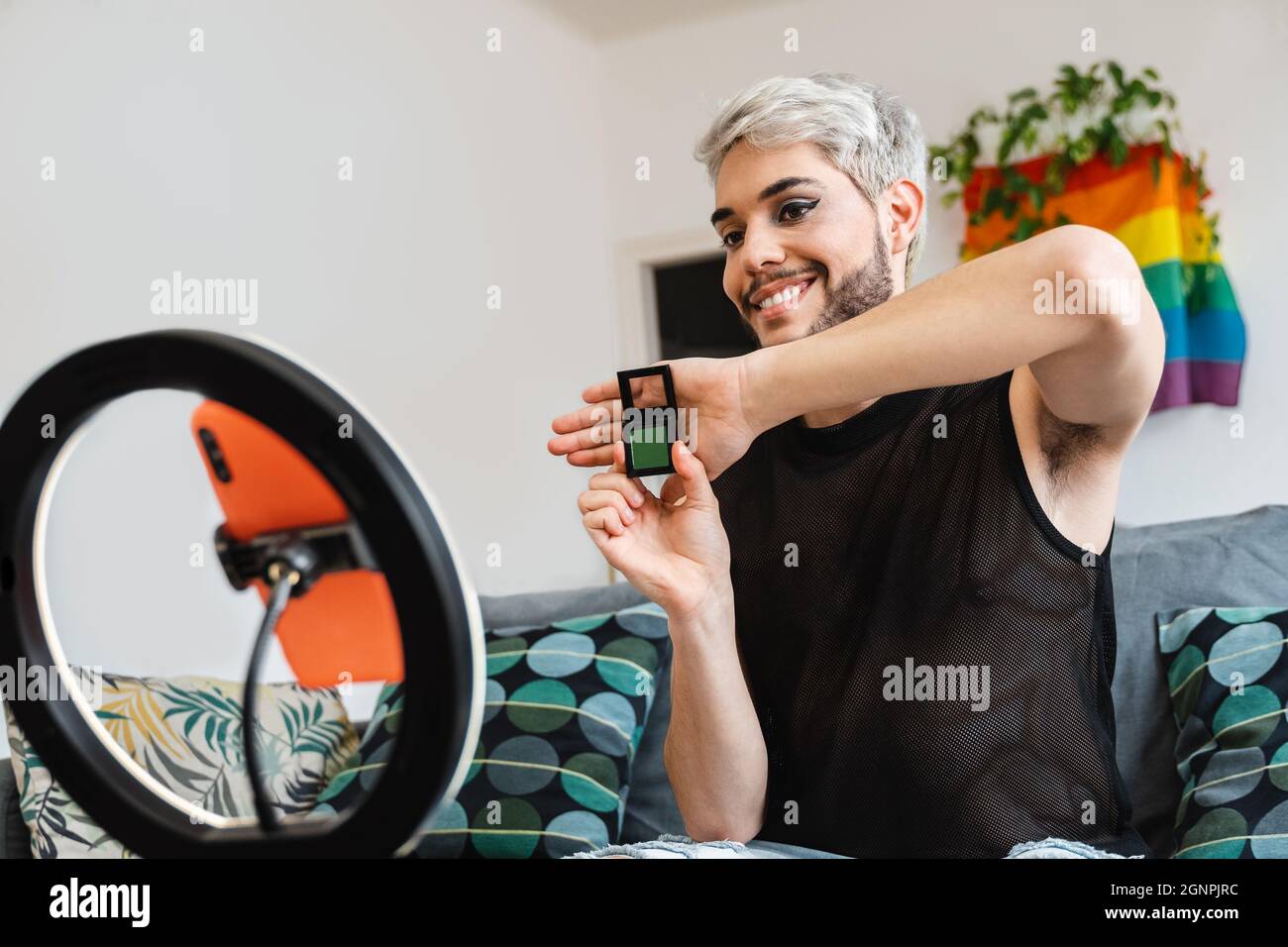 Transgenre streaming multimédia en ligne maquillage vidéo tutorial avec téléphone mobile à la maison - LGBTQ, gay, technologie tendance concept - Focus en face Banque D'Images