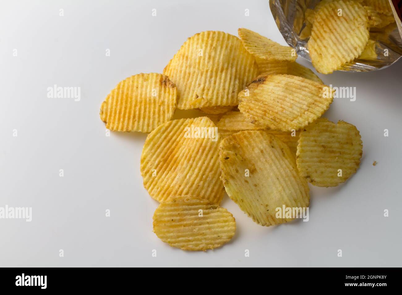 Tas de chips de pommes de terre scintillantes isolées sur fond blanc avec espace de texte Banque D'Images
