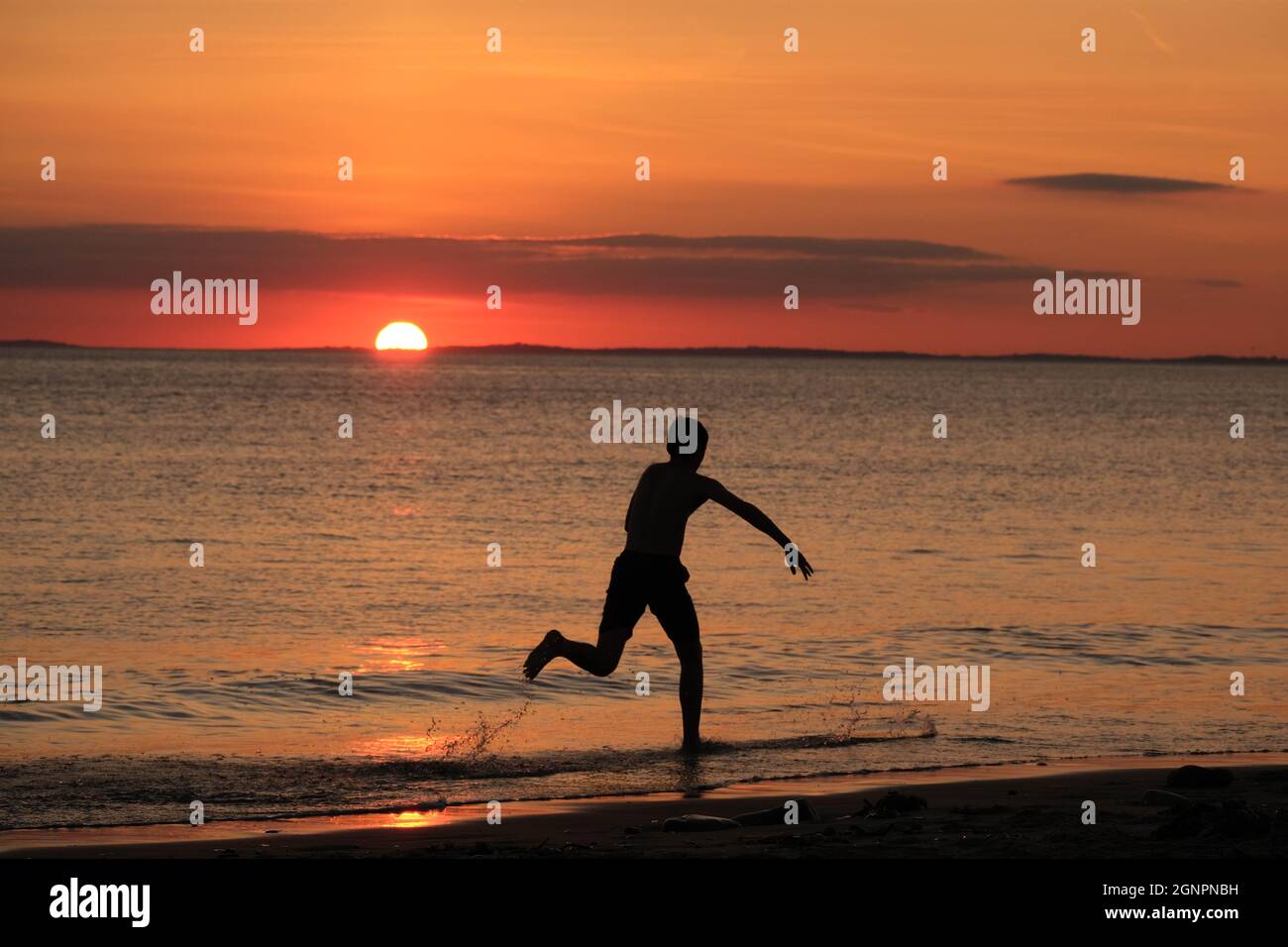 Gower, Swansea, Royaume-Uni. 24 août 2021. Météo au Royaume-Uni: Un garçon aime arnaqueter les hilades sous un soleil couchant, lors d'une soirée sèche, fine et ensoleillée à la plage de Llangennith sur la péninsule de Gower. Les perspectives pour les prochains jours sont pour le même beau temps avec quelques sorts chauds.Credit: Gareth Llewelyn/Alamy Banque D'Images