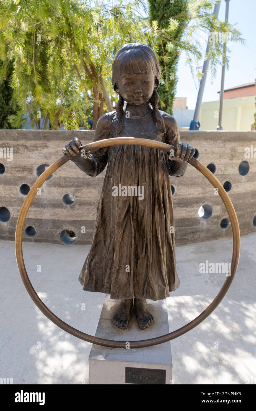 Sculpture en bronze intitulée «le cercle» par l'artiste Yiota Ioannidou, située dans la vieille ville de Paphos, elle représente une petite fille tenant un hula dans ses mains. Banque D'Images