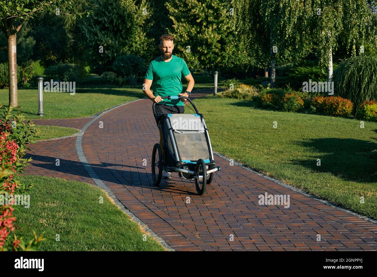 Papa avec bébé en plein air. Le jeune père marche avec son fils dans une poussette au parc de la ville Banque D'Images