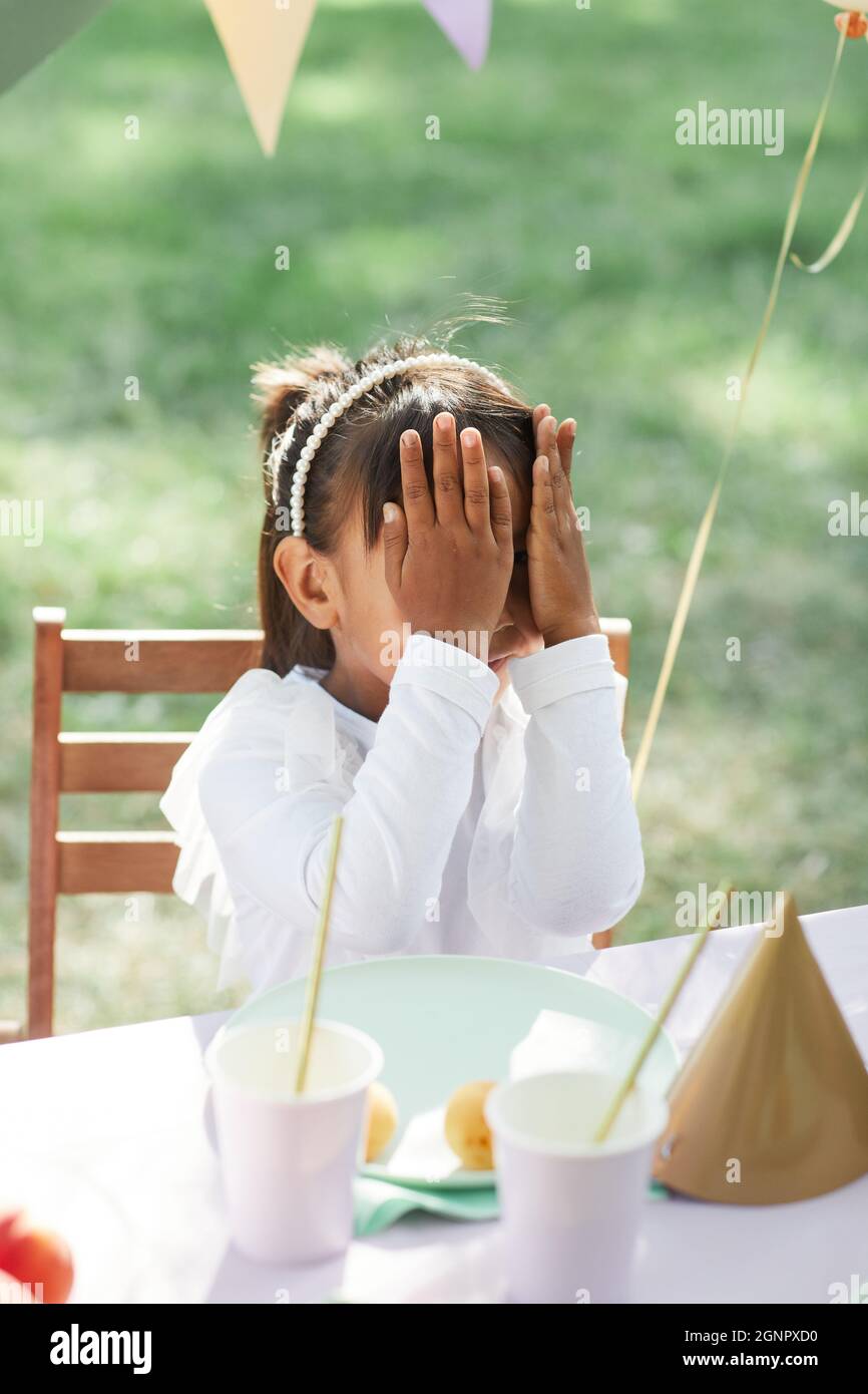 Jolie petite fille à la table de pique-nique extérieure décorée de ballons pour la fête d'anniversaire en été Banque D'Images