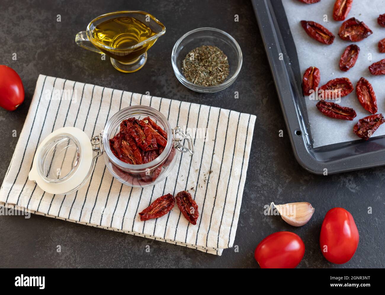 tomates séchées dans un pot en verre sur une table sombre Banque D'Images