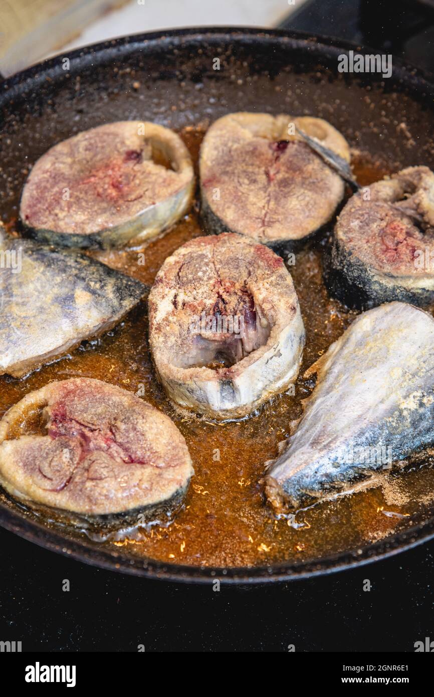 Émincé de poisson frais de bonito frit dans une poêle noire. Mise au point  sélective Photo Stock - Alamy