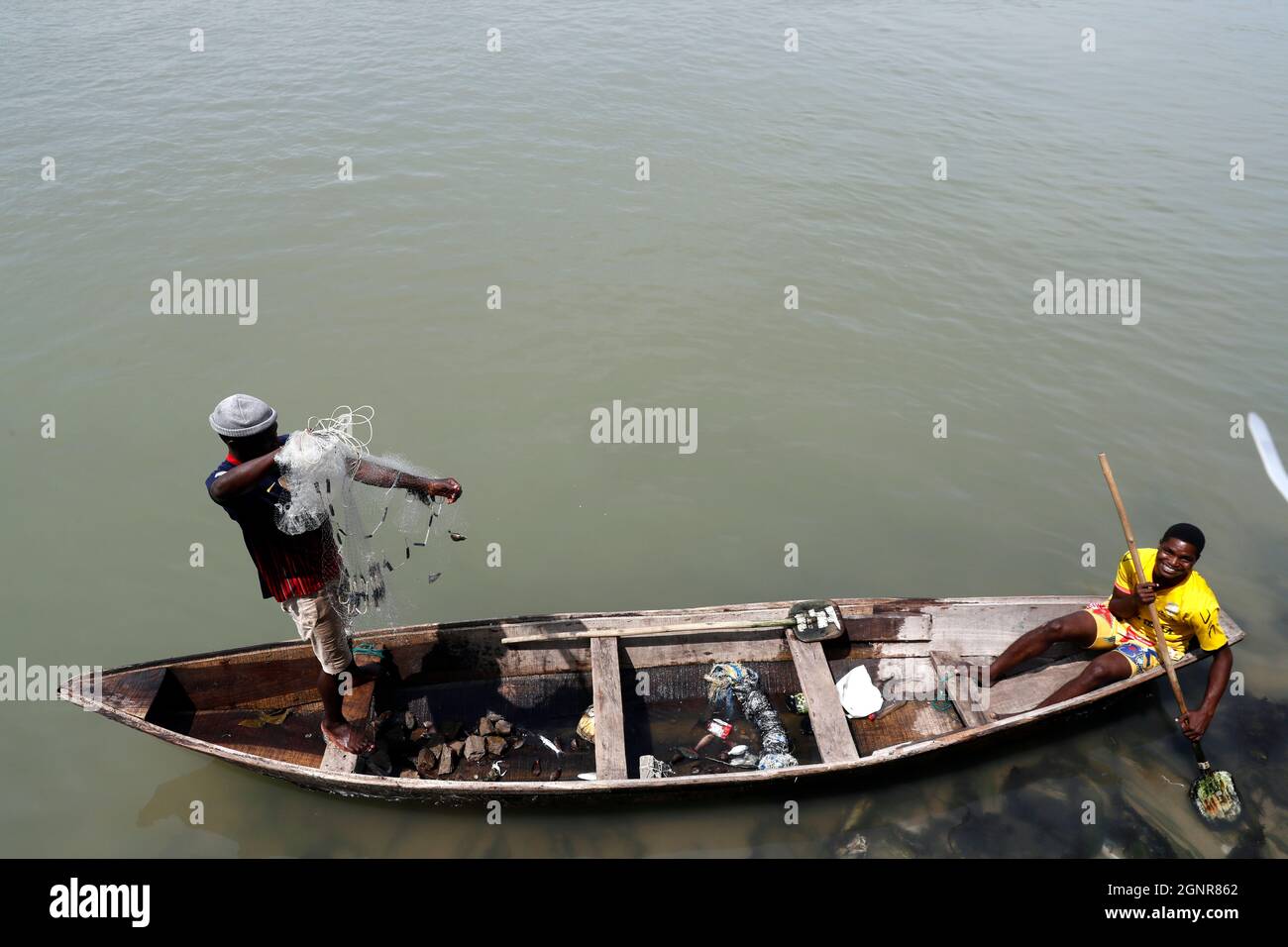 Pêcheur africain jetant le filet dans la rivière de manière traditionnelle. Bénin. Banque D'Images