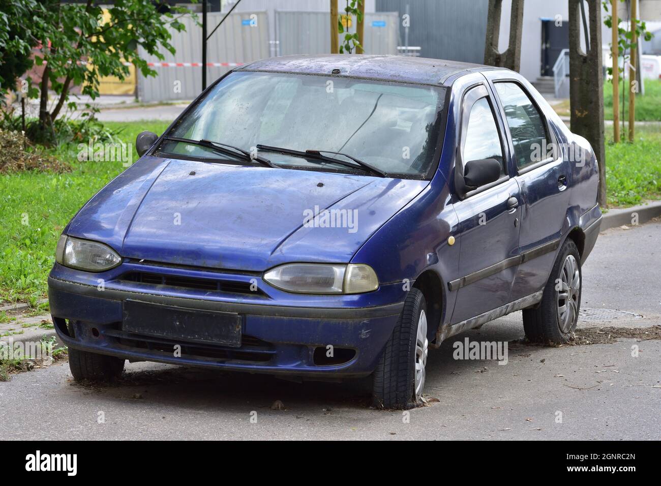 La voiture endommagée se trouve sur des pneus à plat dans le parking. Mettre au rebut Photo