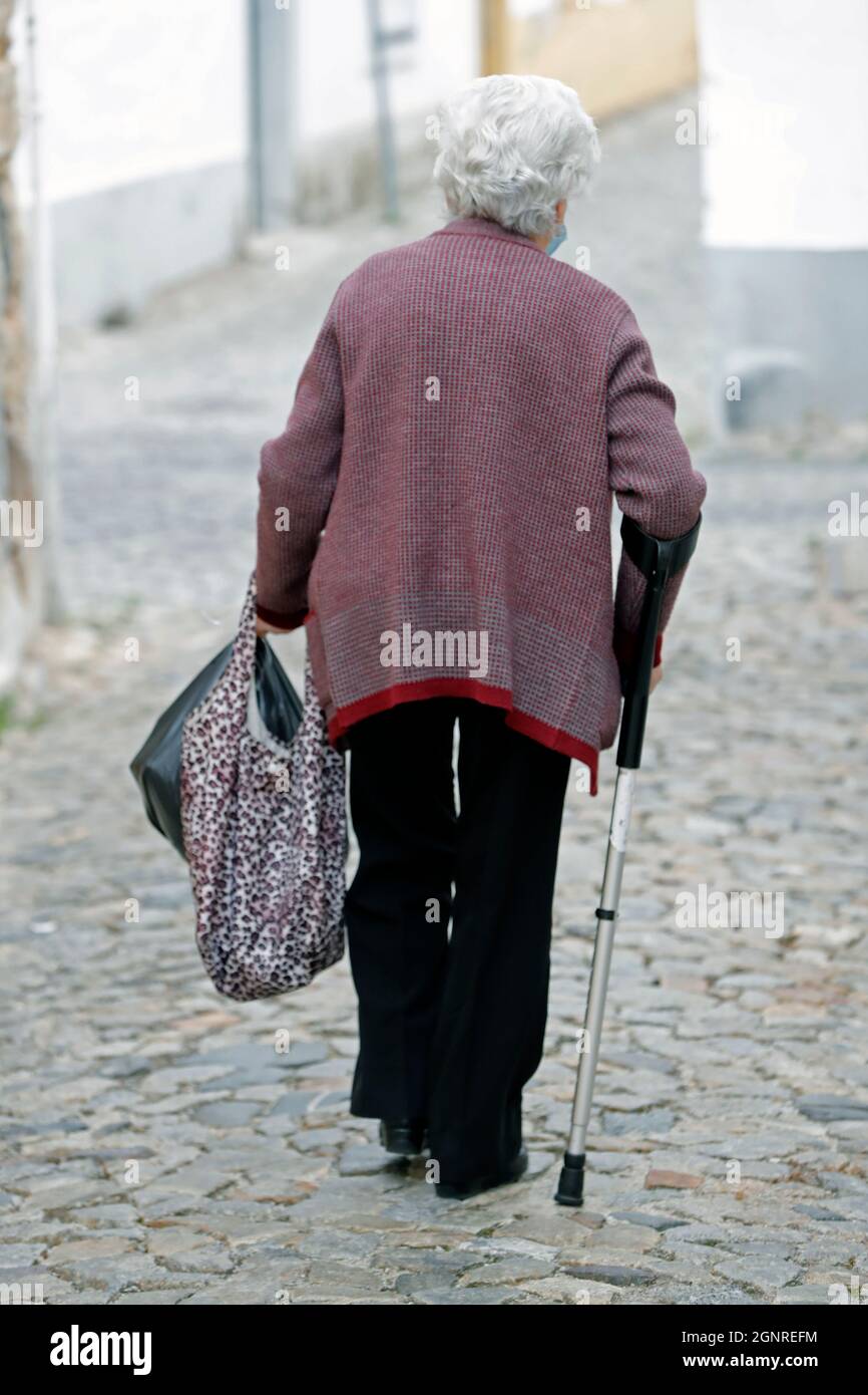 Femme âgée marchant sur la rue de pierre; Evora. Portugal. Banque D'Images