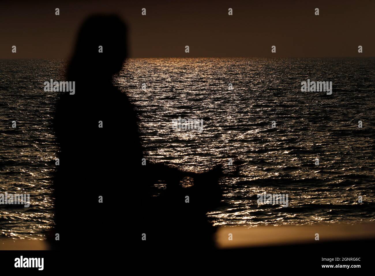 Femme pratiquant la pose de yoga et la méditation au coucher du soleil. Silence et relaxation concept. Banque D'Images