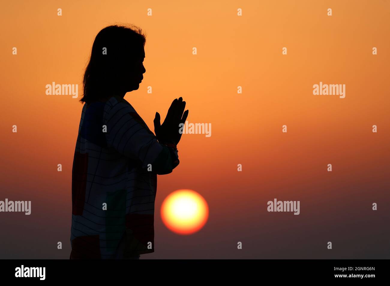 Femme pratiquant la pose de yoga et la méditation au coucher du soleil. Silence et relaxation concept. Banque D'Images
