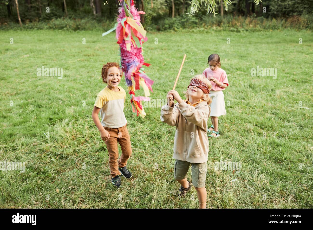 Portrait En Grand Angle D Un Garcon Jouant Au Jeu De Pinata A La Fete D Anniversaire A L Exterieur Et Tenant La Chauve Souris Espace De Copie Photo Stock Alamy