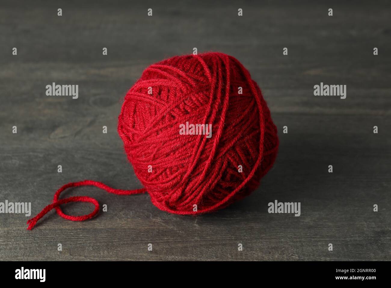 Boule de fil rouge sur table en bois gris Banque D'Images