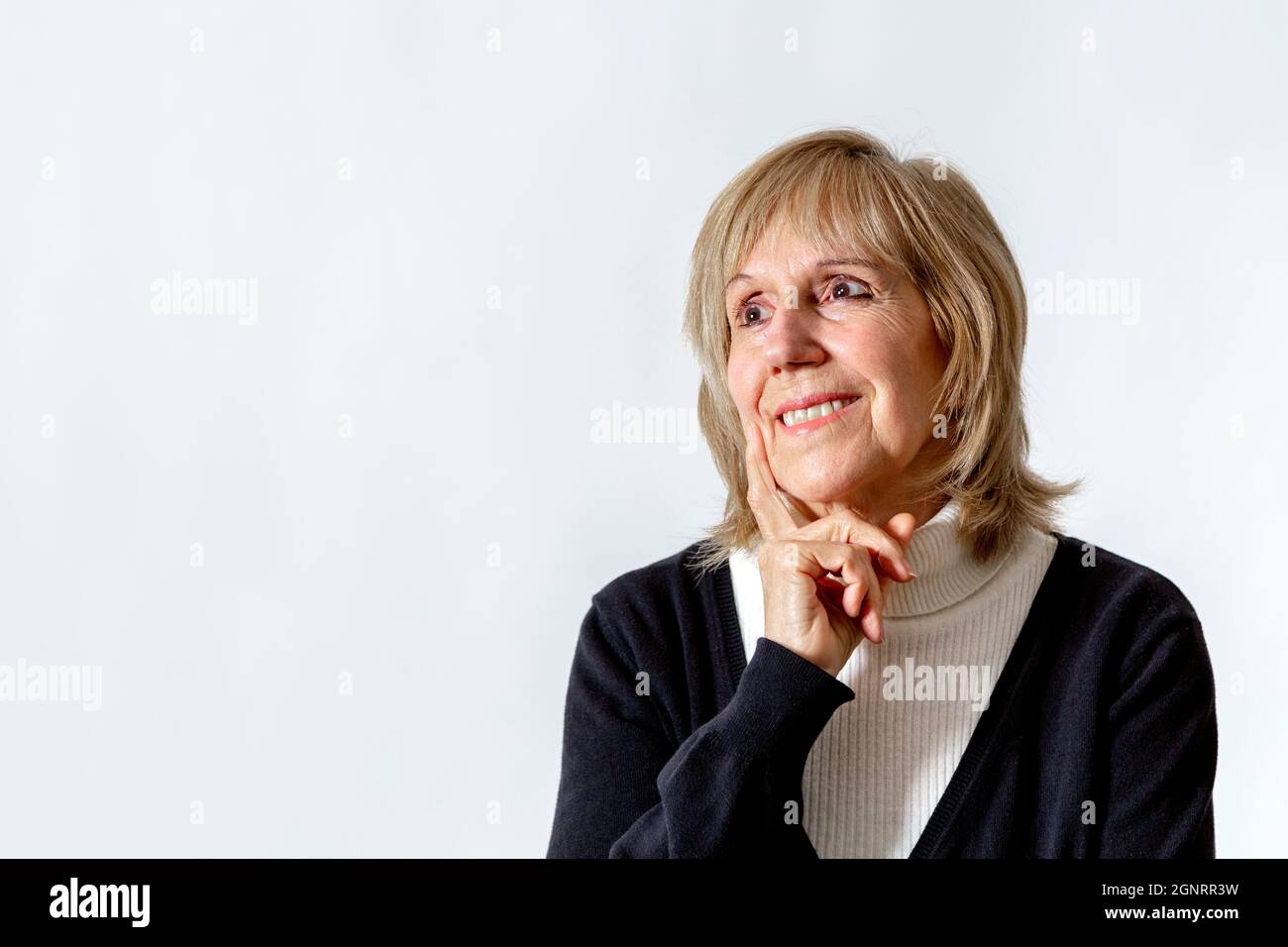 Avoir une idée. Femme âgée en position de réflexion avec la main sur le visage. Arrière-plan blanc. Environ 65 ans de femme. Banque D'Images