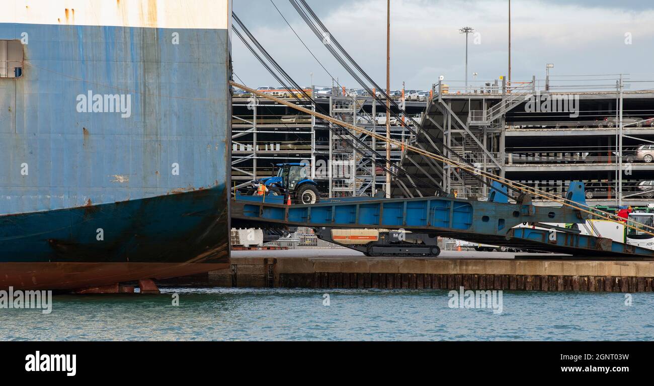 Southampton docks, Angleterre, Royaume-Uni. 2021. Tracteur agricole chargé sur un navire commercial Roro via une rampe sur le quai. Banque D'Images