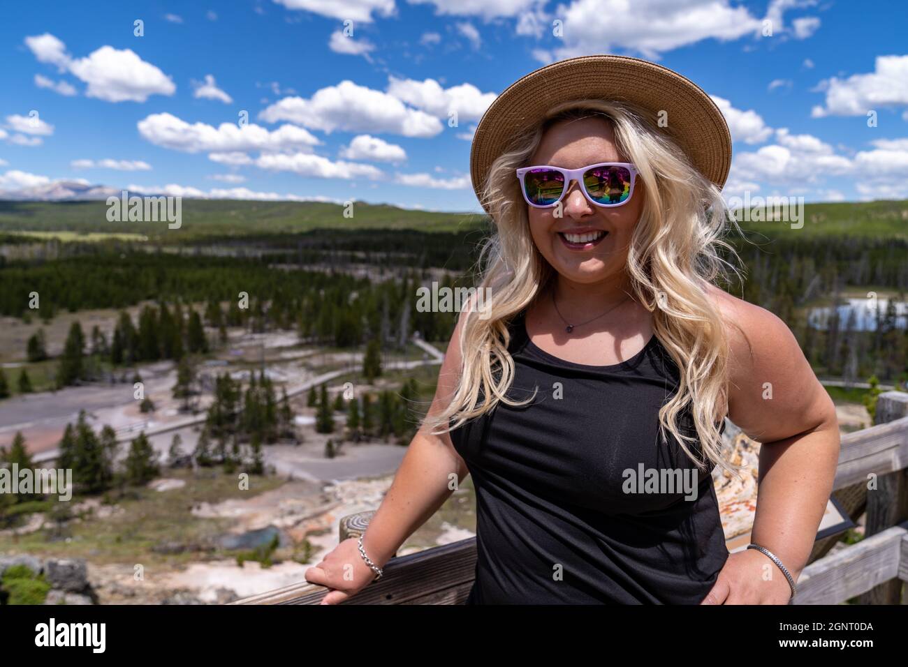 Une femme à la mode pose dans des pots de peinture d'artiste dans le parc national de Yellowstone, portant une robe et un chapeau Banque D'Images