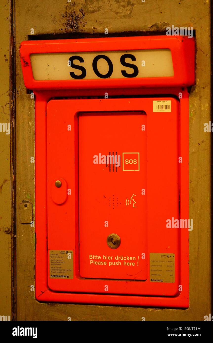 FRANCFORT, ALLEMAGNE - 12 mai 2021 : boîte d'appel d'urgence dans une station de métro. Couleur de signal orange dans la lumière néon. Banque D'Images