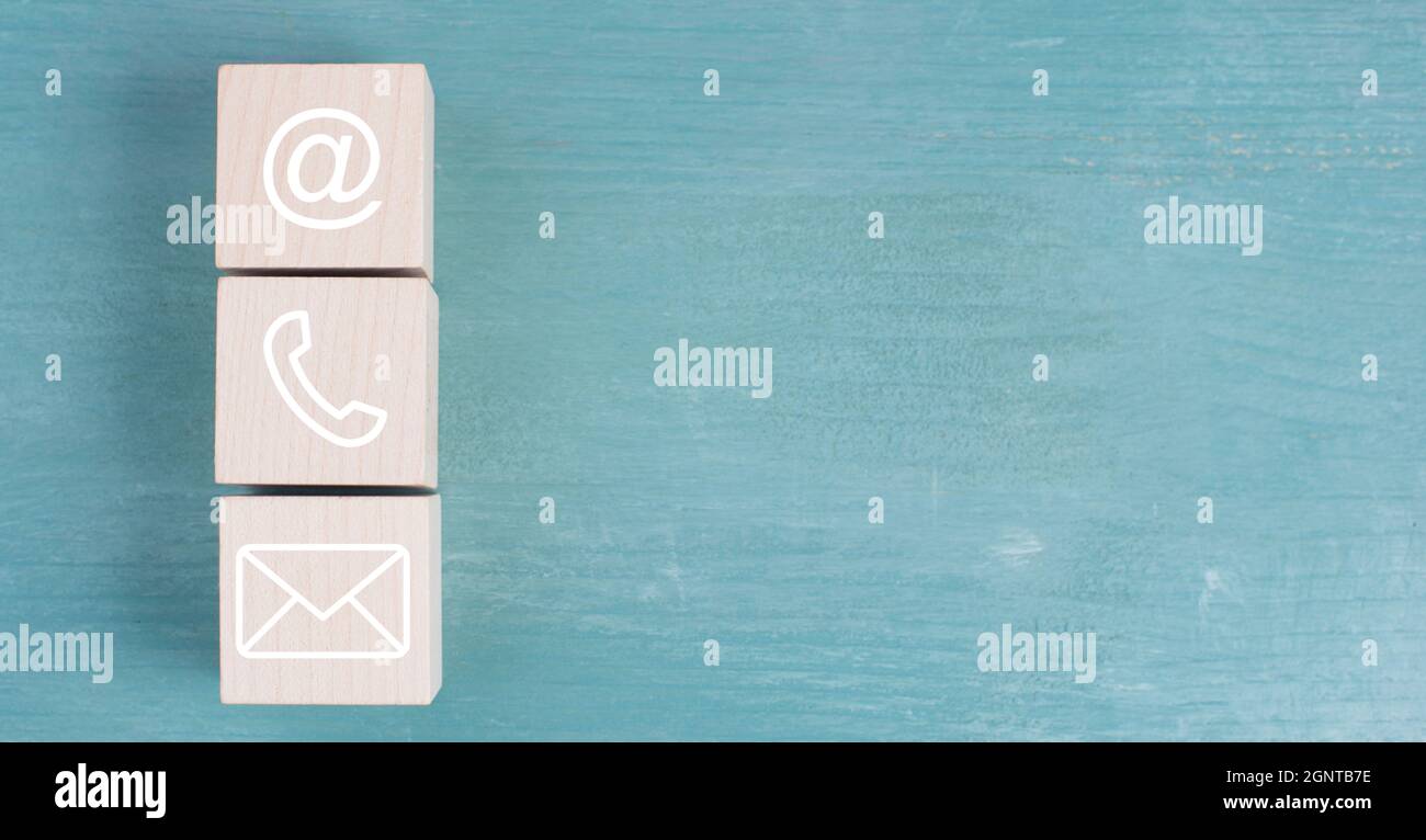 Symboles pour e-mail, téléphone et bulletin d'information sur des blocs de bois, fond bleu Banque D'Images