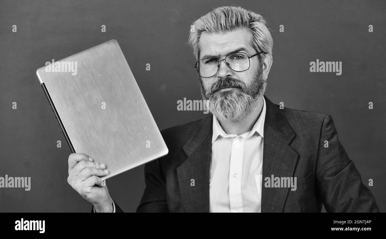 Sauvetage scolaire. Professeur porter lunettes tenir ordinateur portable surfer sur Internet. Beaucoup d'informations. Homme barbu ordinateur portable moderne surfer sur Internet. Intéressant Banque D'Images