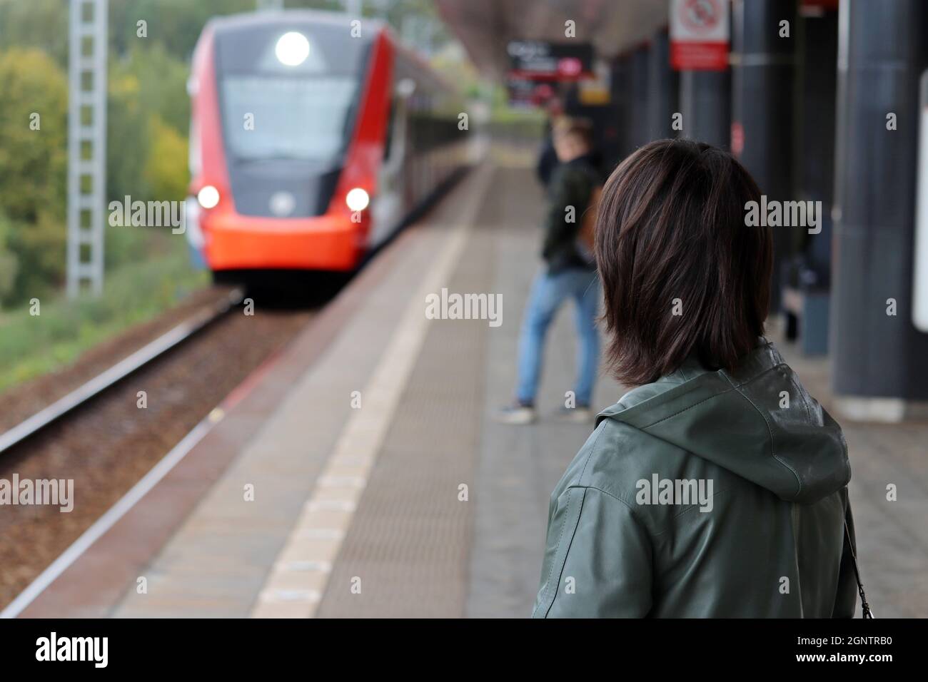 Personnes attendant l'arrivée du train à la gare. Passagers de train de banlieue à l'automne Banque D'Images